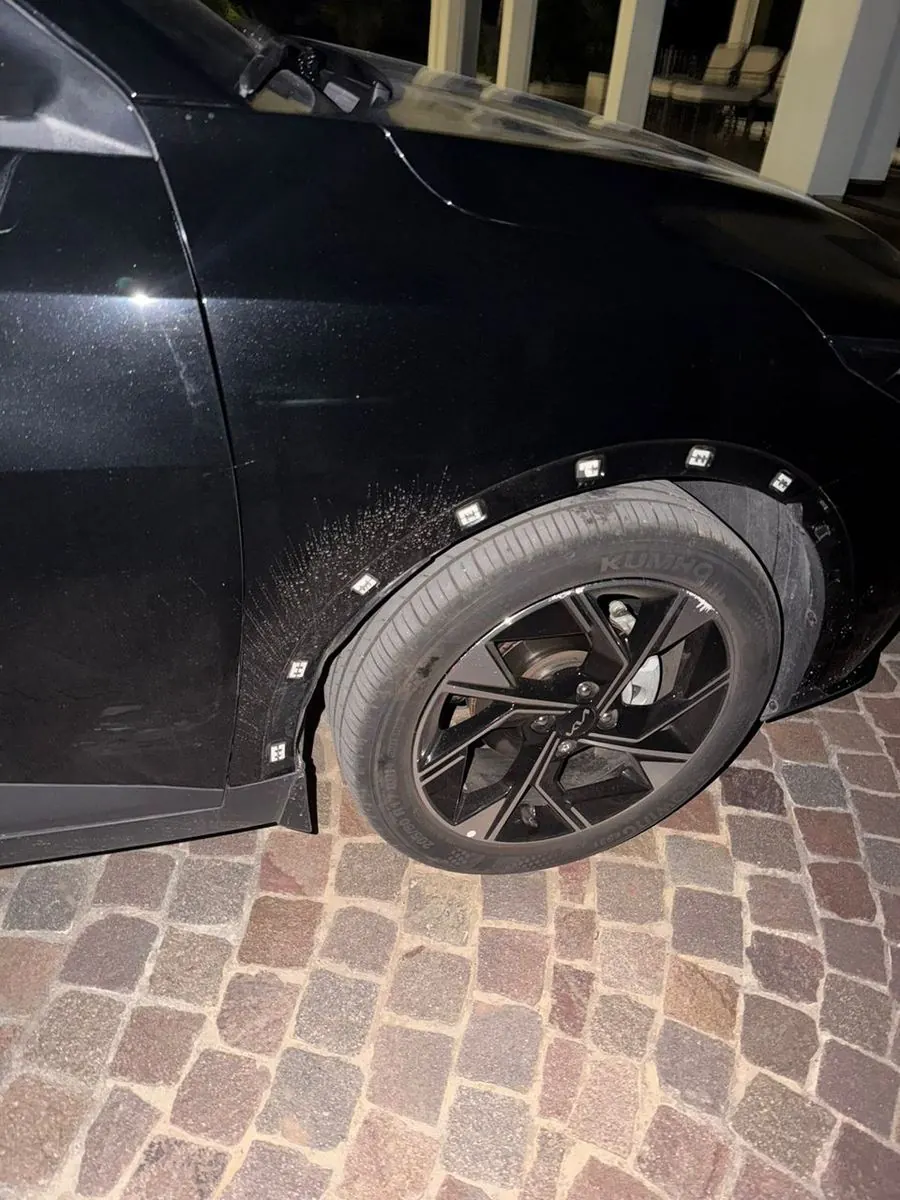 En proceso: Kia negra con la zona cubierta con papel y cinta, lista para pintar